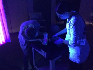 Lara Kaplan and VMFA Assistant Conservator Ainslie Harrison examining a terracotta under UV light
